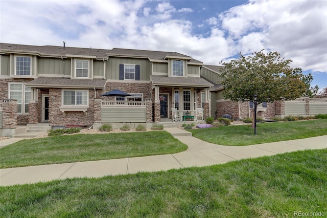 4784 Raven Run, Broomfield, CO 80023 - view of front facade with board and batten siding, roof with shingles, stone siding, and a front lawn