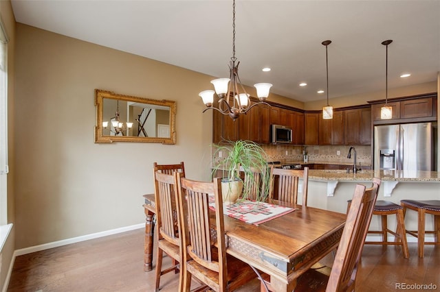 4784 Raven Run, Broomfield, CO 80023 - dining room featuring recessed lighting, baseboards, an inviting chandelier, and light wood-style flooring