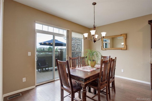 4784 Raven Run, Broomfield, CO 80023 - dining space featuring visible vents, baseboards, an inviting chandelier, and hardwood / wood-style flooring