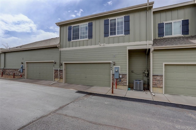 4784 Raven Run, Broomfield, CO 80023 - view of front of home featuring board and batten siding, stone siding, an attached garage, and central AC