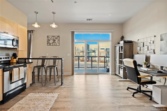 office space featuring wood finished floors, visible vents, and baseboards