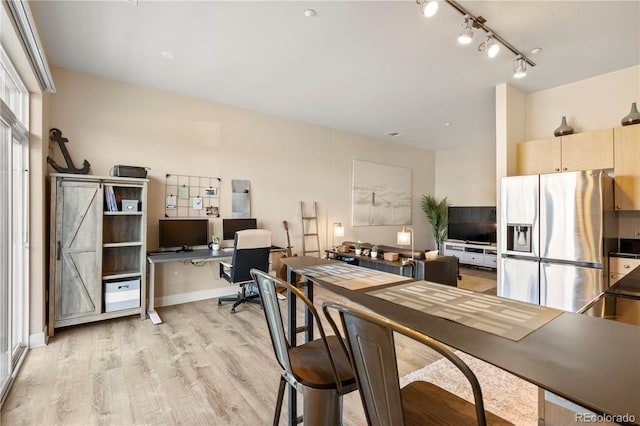 office space featuring track lighting, light wood-style flooring, and baseboards