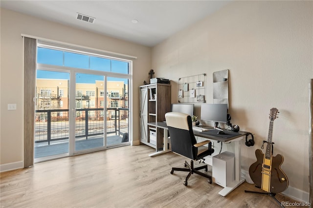 office with wood finished floors, visible vents, and baseboards