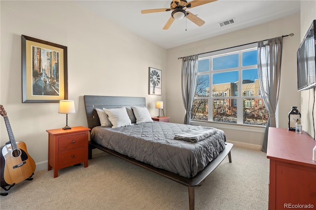 bedroom with light colored carpet, baseboards, and a ceiling fan