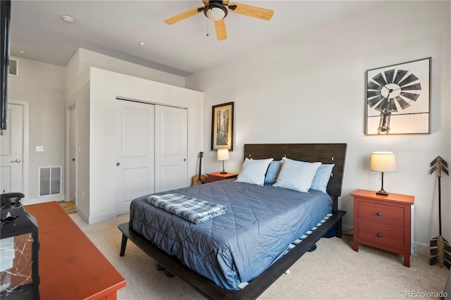 bedroom with light colored carpet, a closet, baseboards, and a ceiling fan