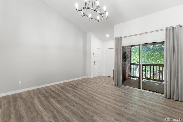 unfurnished room with light hardwood / wood-style flooring, high vaulted ceiling, and an inviting chandelier