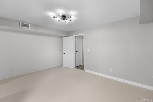 unfurnished room with light carpet and an inviting chandelier