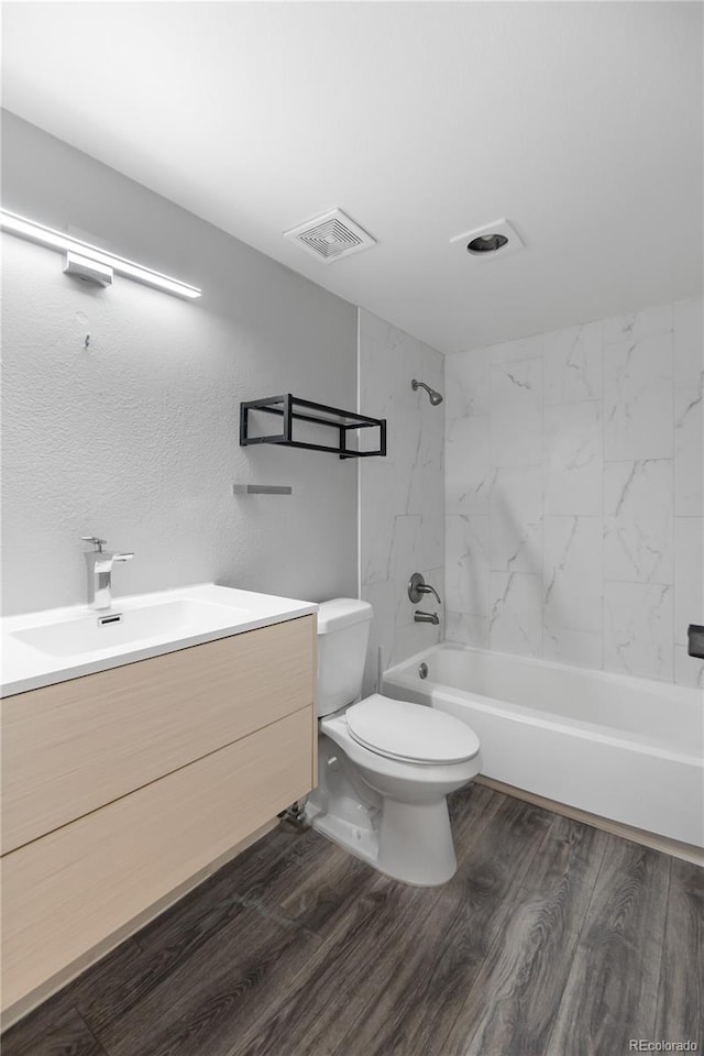 full bathroom with wood-type flooring, vanity, toilet, and tiled shower / bath