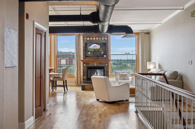 living room featuring hardwood / wood-style flooring, a fireplace, and crown molding