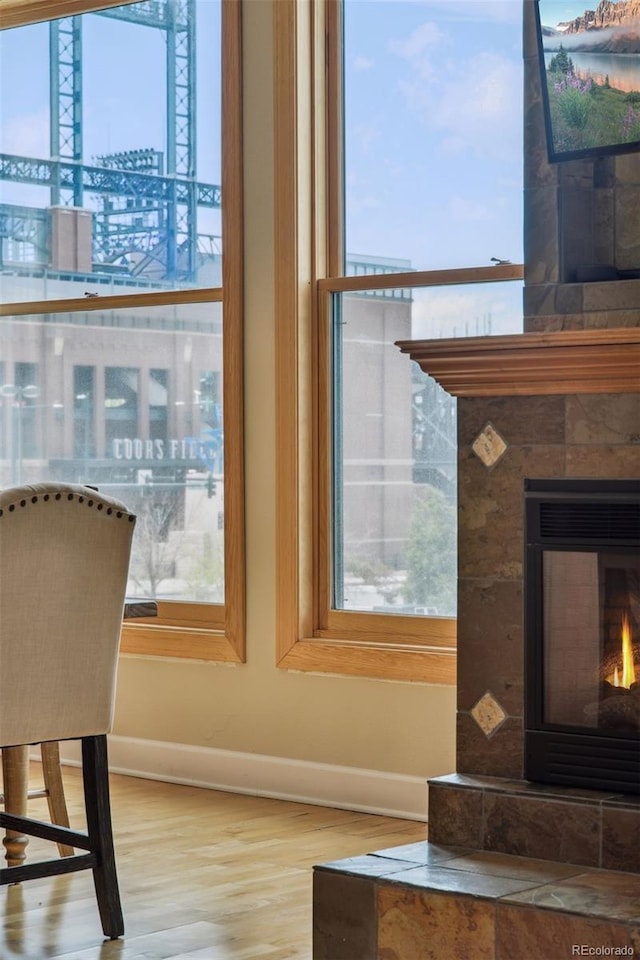 interior details with a tiled fireplace and hardwood / wood-style floors