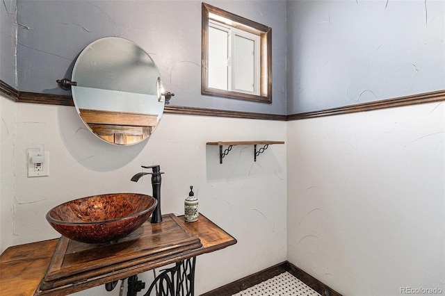 interior space with baseboards and a sink