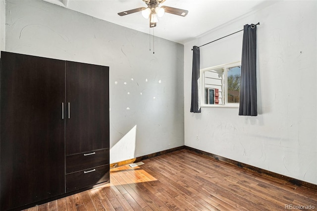 unfurnished bedroom with baseboards, ceiling fan, hardwood / wood-style flooring, and visible vents
