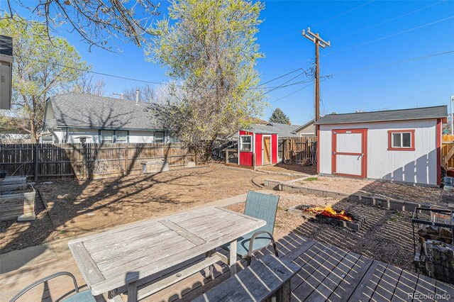 wooden deck with a storage shed, an outdoor structure, and a fenced backyard