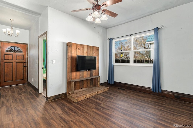 unfurnished living room featuring baseboards, dark wood finished floors, and ceiling fan with notable chandelier