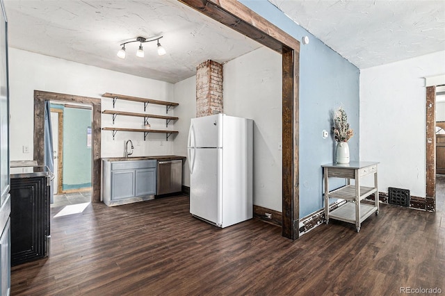 kitchen with open shelves, a sink, dishwasher, freestanding refrigerator, and dark wood-style floors