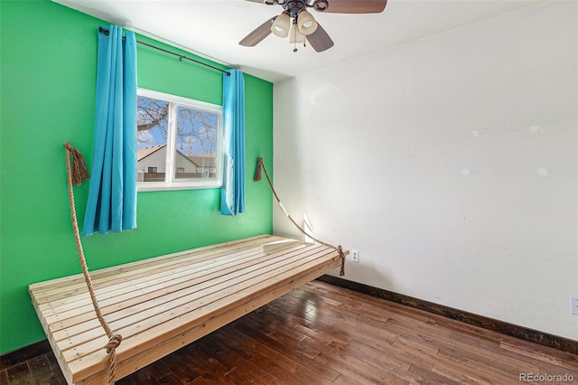 interior space featuring baseboards, ceiling fan, and hardwood / wood-style floors