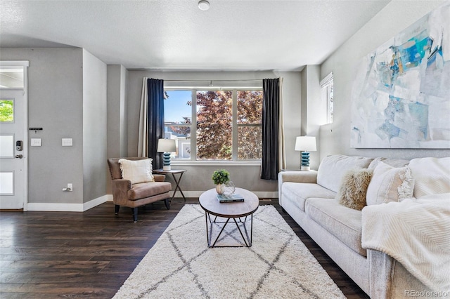 living room featuring dark hardwood / wood-style flooring and a textured ceiling