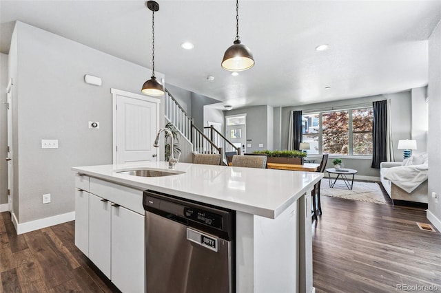 kitchen featuring white cabinetry, stainless steel dishwasher, a kitchen island with sink, and sink