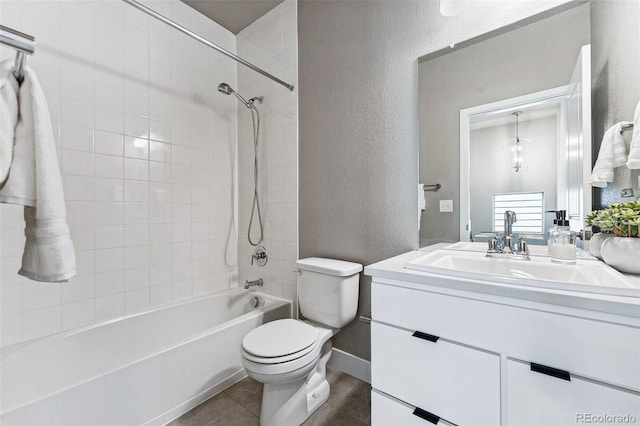 full bathroom with tiled shower / bath, vanity, toilet, and tile patterned floors