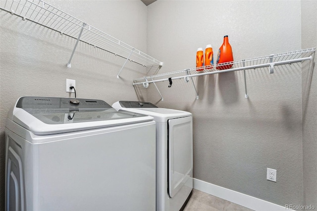 washroom featuring light tile patterned floors and washing machine and clothes dryer