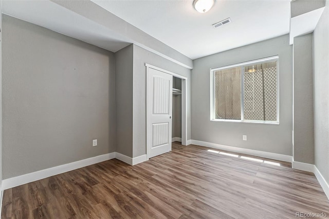 unfurnished bedroom featuring hardwood / wood-style floors and a closet