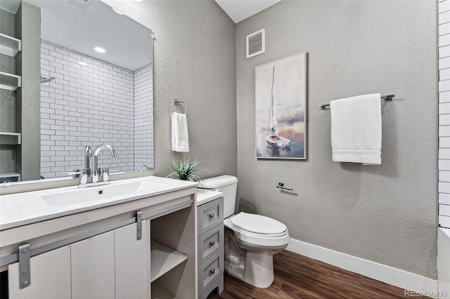 bathroom featuring hardwood / wood-style flooring, vanity, a shower, and toilet