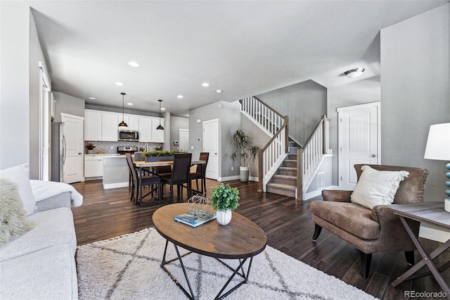 living area with baseboards, dark wood-style floors, recessed lighting, and stairs