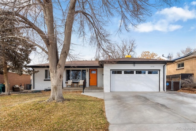 single story home with a garage, central air condition unit, and a front lawn