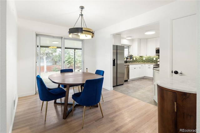 dining space with light hardwood / wood-style floors and sink