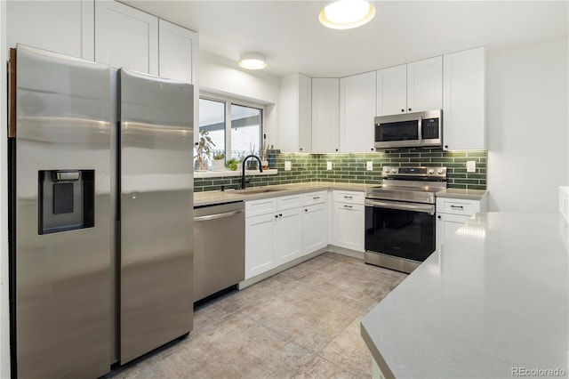 kitchen featuring decorative backsplash, sink, white cabinets, and stainless steel appliances