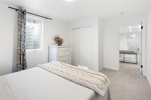 bedroom with light colored carpet and a closet