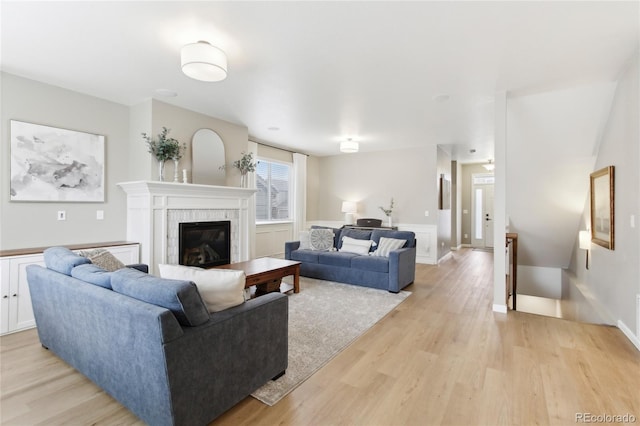 60 Stewart Way, Erie, CO 80516 - living room with light wood-style flooring, a glass covered fireplace, and baseboards