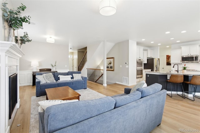 60 Stewart Way, Erie, CO 80516 - living room with light wood-type flooring, stairway, a fireplace, and recessed lighting