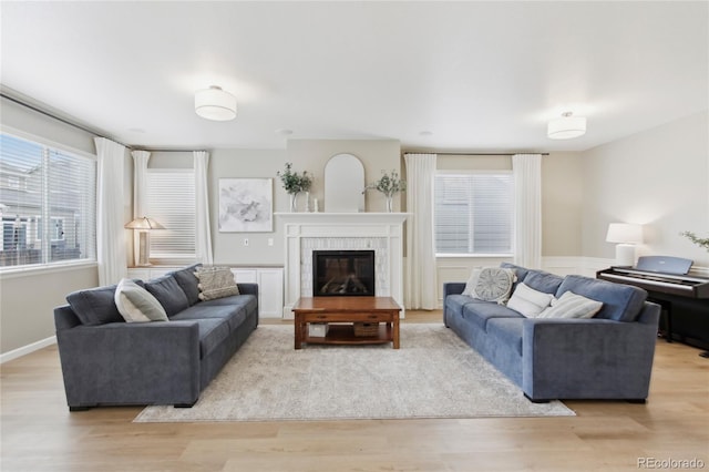 60 Stewart Way, Erie, CO 80516 - living area featuring light wood-type flooring, a tile fireplace, and wainscoting