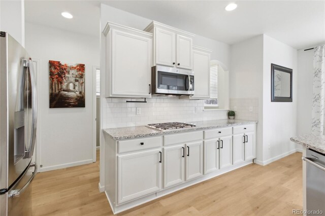 60 Stewart Way, Erie, CO 80516 - kitchen featuring stainless steel appliances, light wood-style flooring, tasteful backsplash, baseboards, and recessed lighting