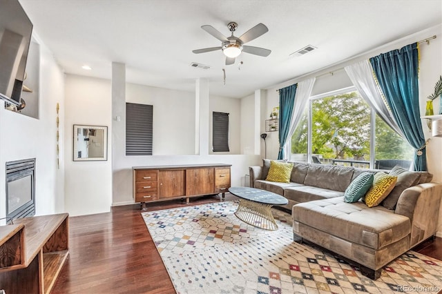 living room with dark hardwood / wood-style flooring and ceiling fan