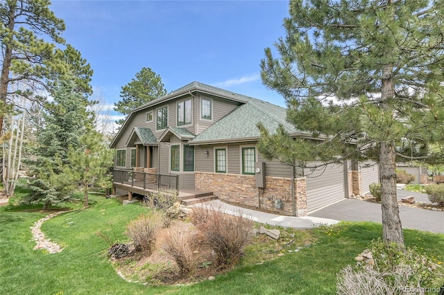 31139 Tahoe Ct, Evergreen, CO 80439 - view of front of property with stone siding, roof with shingles, a front yard, driveway, and a deck