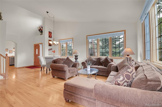 31139 Tahoe Ct, Evergreen, CO 80439 - living room with a chandelier, healthy amount of natural light, light wood-style floors, arched walkways, and high vaulted ceiling