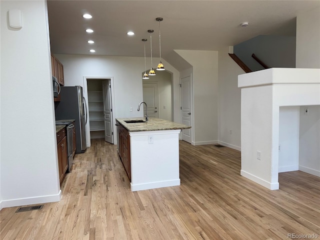 12317 W Gould Ave, Littleton, CO 80127 - kitchen featuring stainless steel appliances, light wood-style flooring, recessed lighting, an island with sink, and pendant lighting