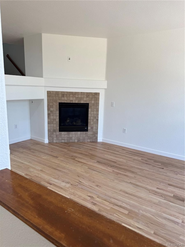 12317 W Gould Ave, Littleton, CO 80127 - unfurnished living room featuring light wood-style flooring and a fireplace