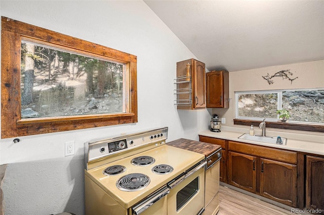 200 Crest Dr, Idaho Springs, CO 80452 - kitchen featuring electric range, lofted ceiling, light countertops, and light wood-style flooring