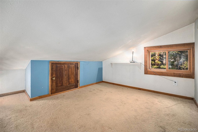200 Crest Dr, Idaho Springs, CO 80452 - additional living space with vaulted ceiling, carpet flooring, and a textured ceiling