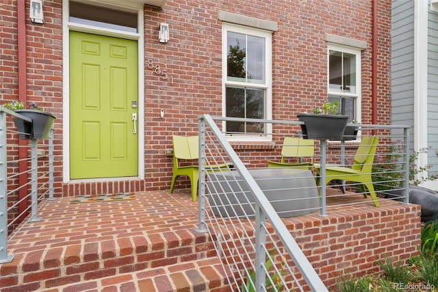 view of exterior entry featuring brick siding