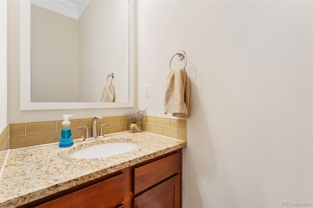 bathroom featuring crown molding, tasteful backsplash, and vanity