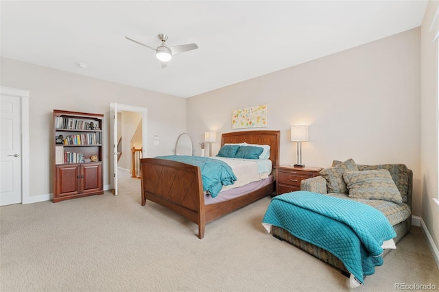 bedroom featuring light colored carpet, baseboards, and ceiling fan