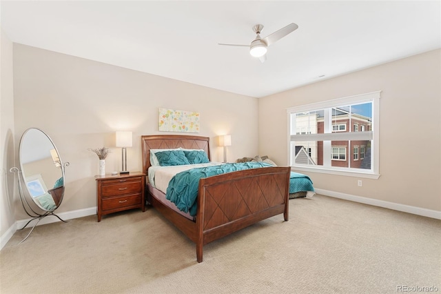 bedroom with light colored carpet, baseboards, and a ceiling fan