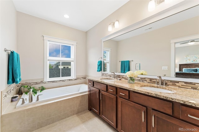ensuite bathroom with a sink, a bath, visible vents, and tile patterned floors