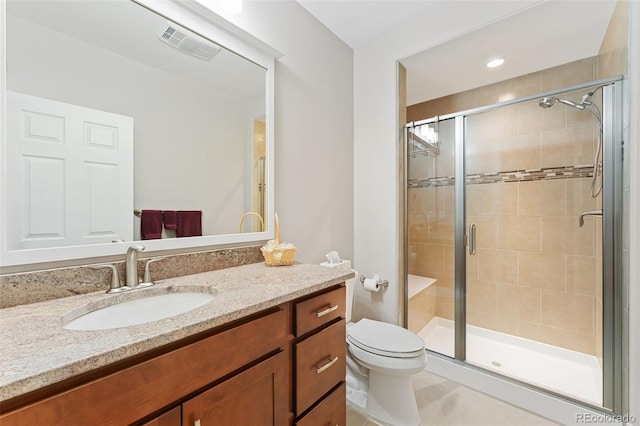 bathroom featuring toilet, vanity, visible vents, tile patterned floors, and a stall shower