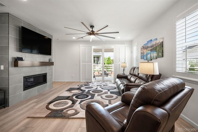 9157 Rio Lado St, Littleton, CO 80125 - living area featuring wood finished floors, a ceiling fan, a tiled fireplace, baseboards, and recessed lighting