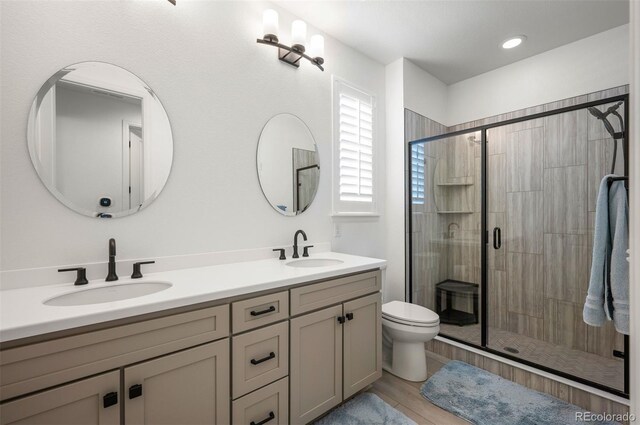 9157 Rio Lado St, Littleton, CO 80125 - bathroom featuring a shower stall, double vanity, and toilet
